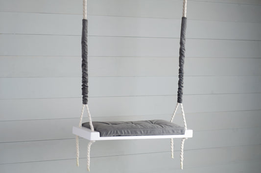 Adult Inside White Swing With A Gray Seat